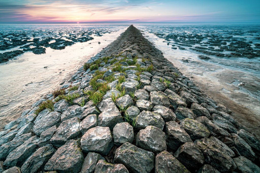 sentiero di rocce che divide due mari e si perde all'orizzonte