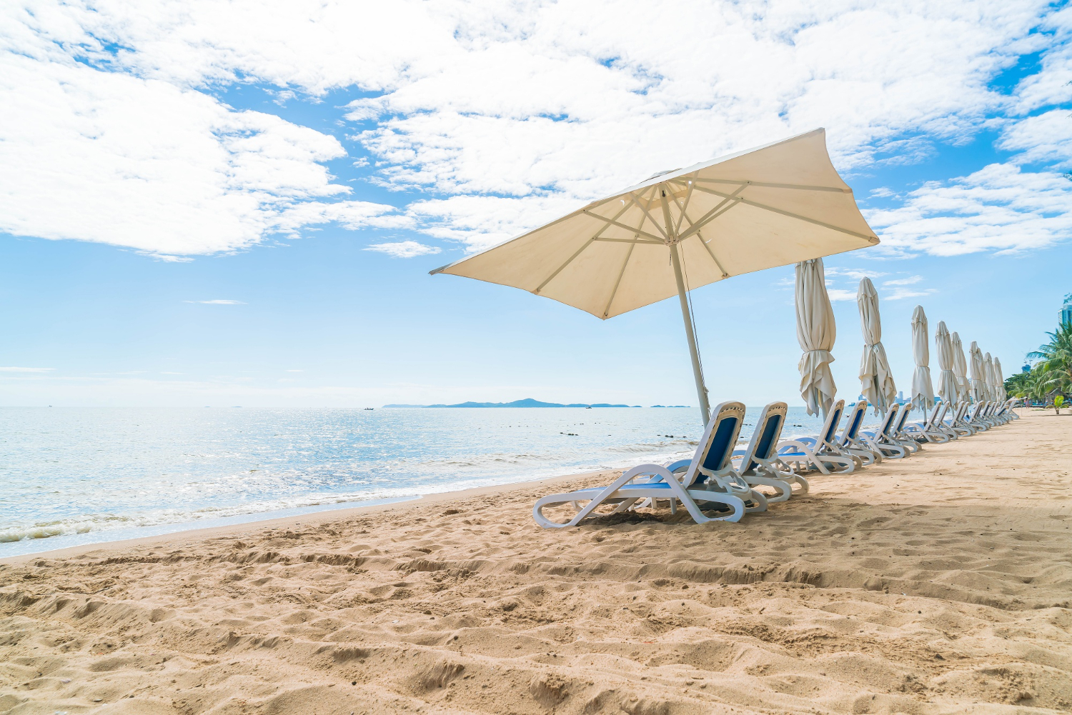 ombrelloni e lettini su una spiaggia di sabbia chiara